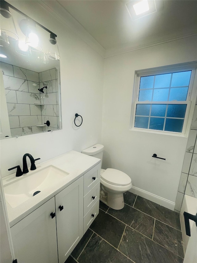 bathroom with baseboards, toilet, ornamental molding, a tile shower, and vanity