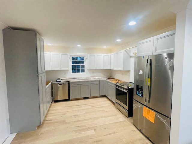 kitchen with appliances with stainless steel finishes, recessed lighting, white cabinetry, and light wood-style floors