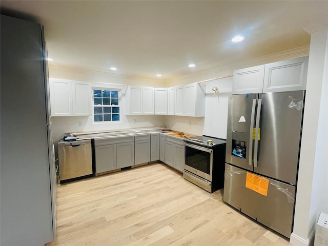 kitchen featuring stainless steel appliances, recessed lighting, light countertops, light wood-style floors, and white cabinetry