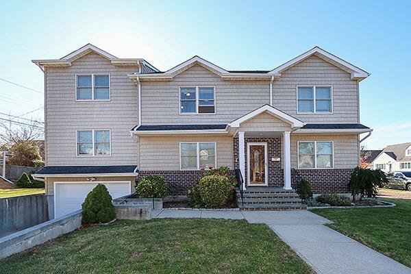 view of front of property featuring a garage, a front yard, and brick siding