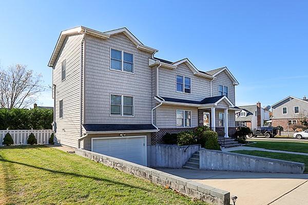 view of front of property featuring a front lawn, an attached garage, and fence