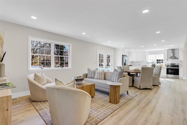 living room with recessed lighting, french doors, baseboards, and light wood finished floors