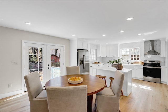 dining room with french doors, light wood-style flooring, and recessed lighting