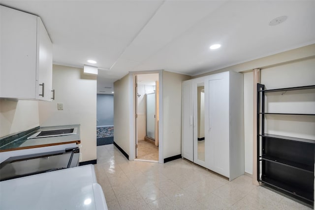 kitchen featuring recessed lighting, baseboards, white cabinets, and stovetop