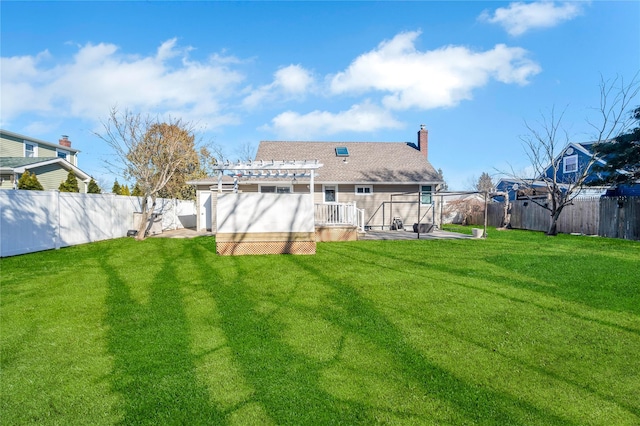 back of house with a shingled roof, a fenced backyard, a chimney, a yard, and a pergola