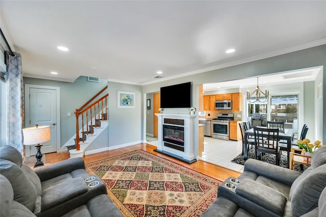 living area featuring stairs, light wood finished floors, recessed lighting, and crown molding