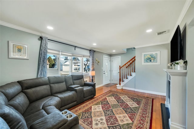 living room with stairs, visible vents, and ornamental molding