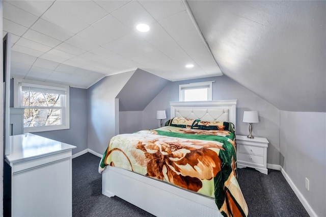 bedroom with lofted ceiling, baseboards, multiple windows, and dark carpet