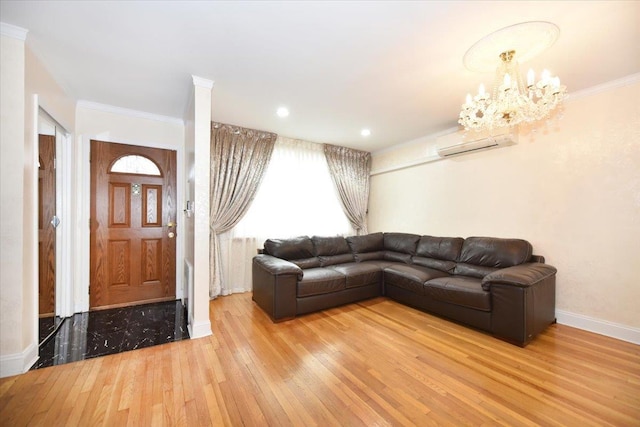 living room with an inviting chandelier, an AC wall unit, crown molding, and light wood-type flooring