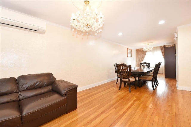 dining space featuring an inviting chandelier, a wall unit AC, light wood-style floors, and ornamental molding