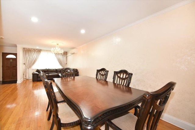 dining space with baseboards, light wood-style floors, an inviting chandelier, and crown molding