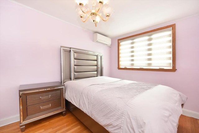 bedroom featuring baseboards, a wall mounted AC, an inviting chandelier, crown molding, and light wood-type flooring