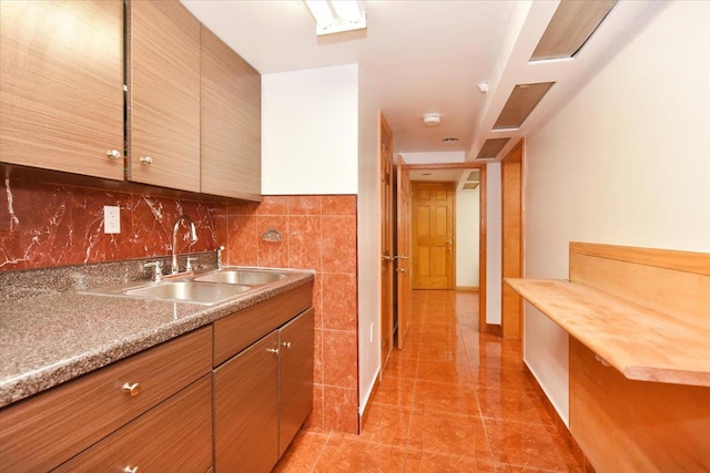 kitchen with light countertops, light tile patterned floors, tasteful backsplash, and a sink