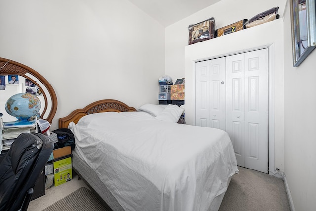 bedroom with a closet, light carpet, and vaulted ceiling