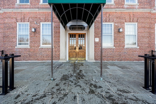 doorway to property featuring french doors and brick siding