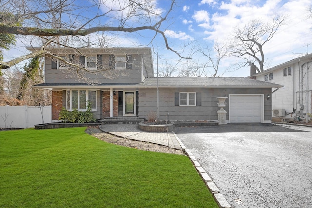 view of front of property featuring driveway, a garage, fence, and a front yard