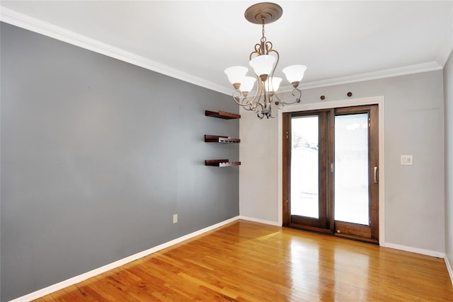 spare room featuring light wood-style flooring, baseboards, and ornamental molding