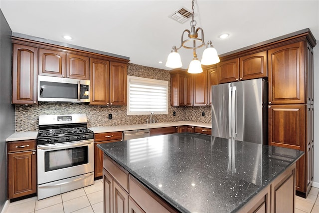 kitchen with visible vents, decorative backsplash, a center island, stainless steel appliances, and light tile patterned flooring