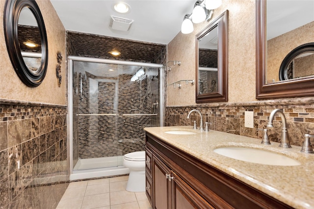 full bathroom featuring visible vents, toilet, a sink, and tile walls