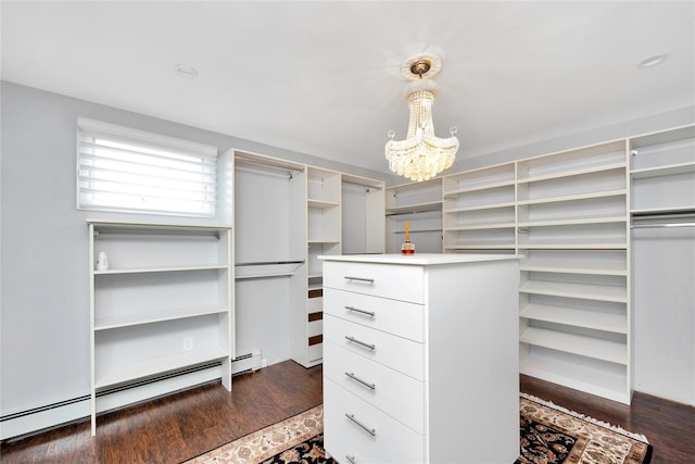 walk in closet with a baseboard heating unit, dark wood-type flooring, and an inviting chandelier