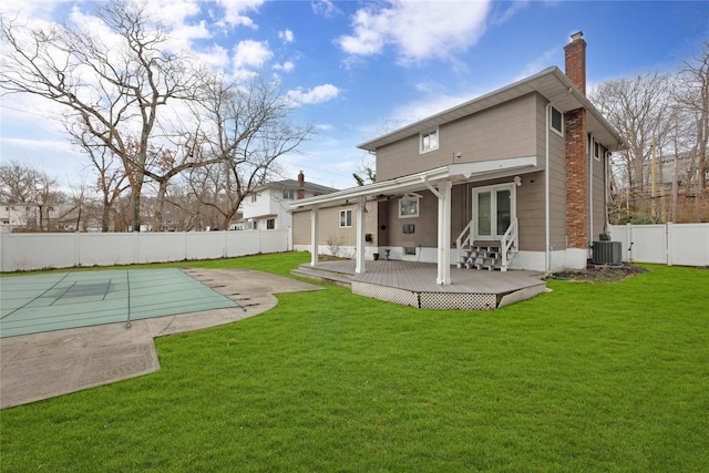 rear view of property featuring entry steps, a fenced in pool, a fenced backyard, a chimney, and central AC