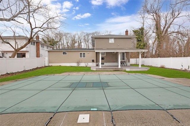 rear view of house featuring a patio area, a fenced backyard, and a yard