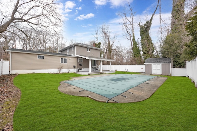 rear view of property featuring a fenced in pool, an outbuilding, a fenced backyard, and a storage unit