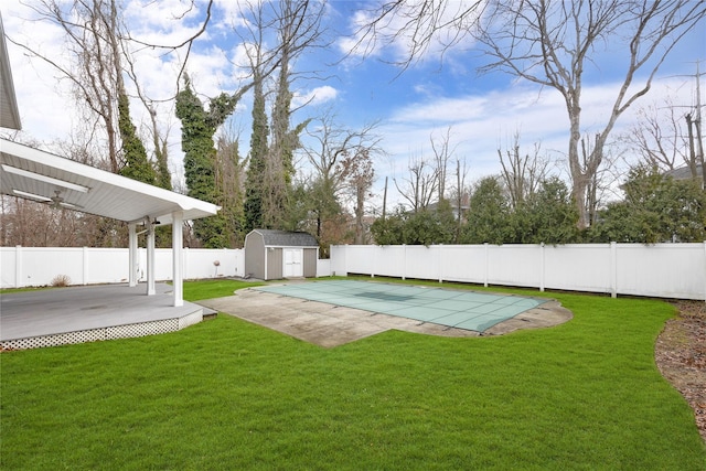 view of yard with an outbuilding, a patio, a fenced backyard, a storage shed, and a fenced in pool