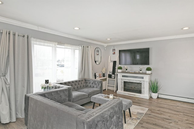 living room with ornamental molding, baseboard heating, a fireplace, and wood finished floors