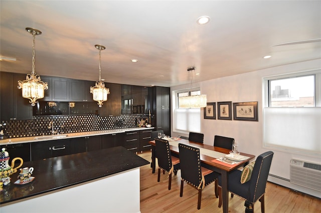 dining space featuring a chandelier, light wood-type flooring, baseboard heating, and recessed lighting