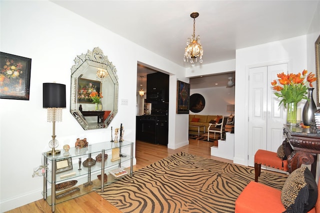 hallway with an inviting chandelier, baseboards, and wood finished floors