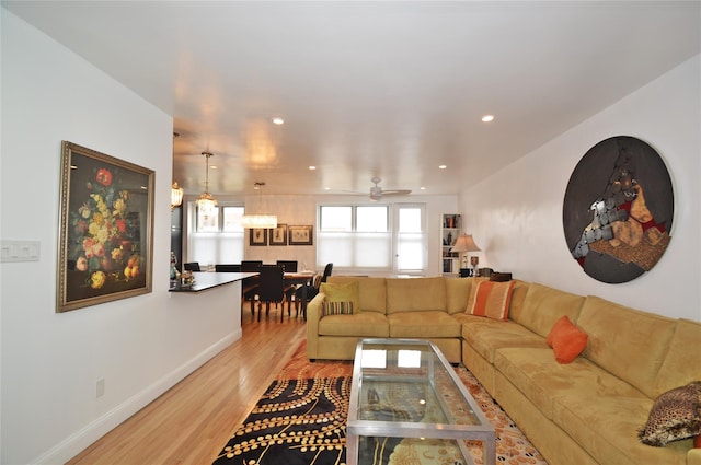 living room featuring light wood-style flooring, baseboards, a ceiling fan, and recessed lighting