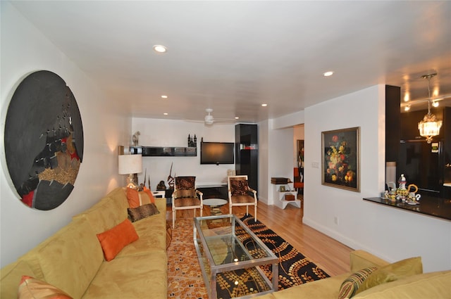 living area featuring baseboards, a ceiling fan, wood finished floors, and recessed lighting