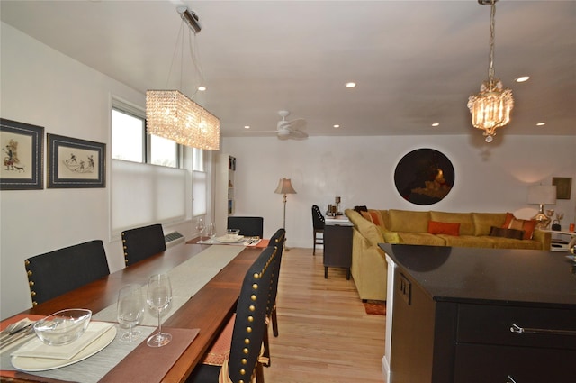 dining area with light wood-type flooring, ceiling fan with notable chandelier, and recessed lighting