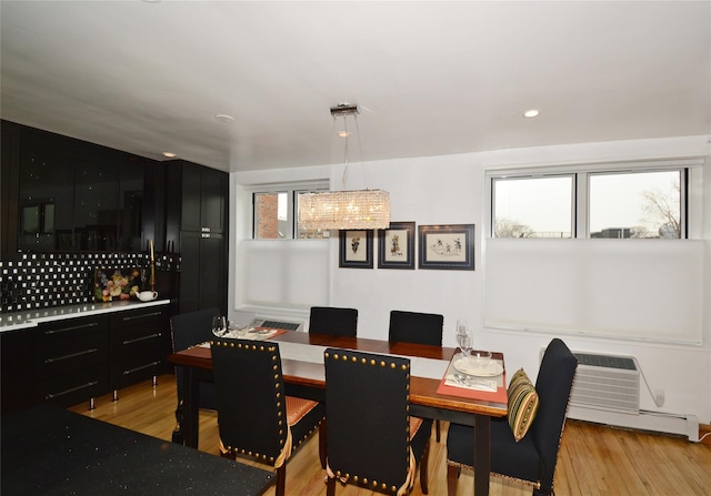 dining area with a baseboard heating unit, light wood finished floors, a wall unit AC, and recessed lighting