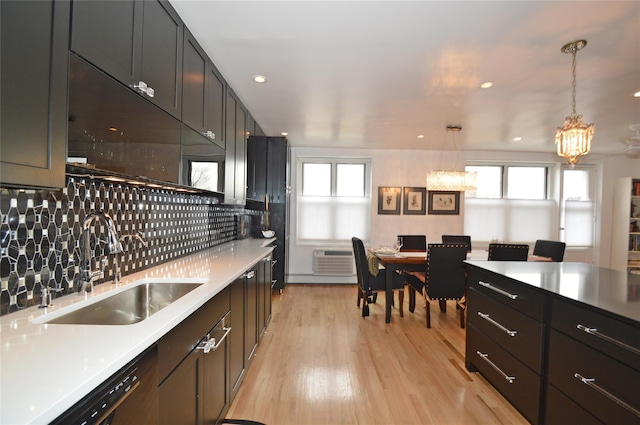 kitchen with a sink, a wall mounted AC, decorative backsplash, dishwasher, and light wood finished floors