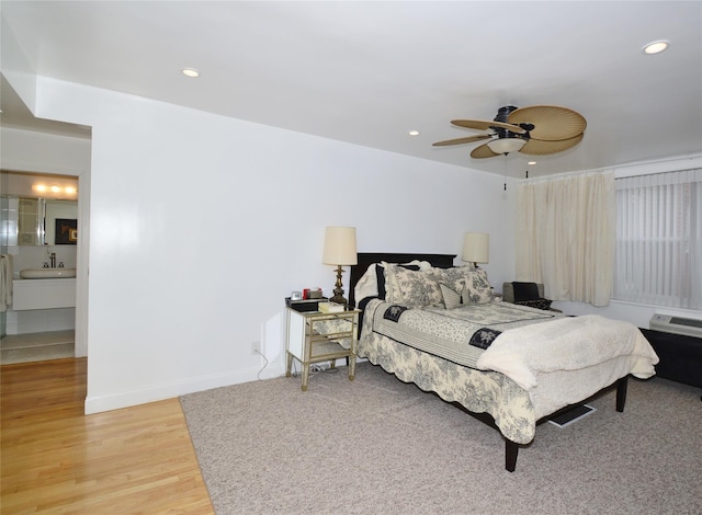 bedroom featuring baseboards, light wood finished floors, a sink, and recessed lighting