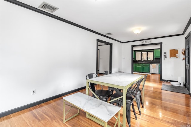 dining space featuring baseboards, ornamental molding, visible vents, and light wood-style floors