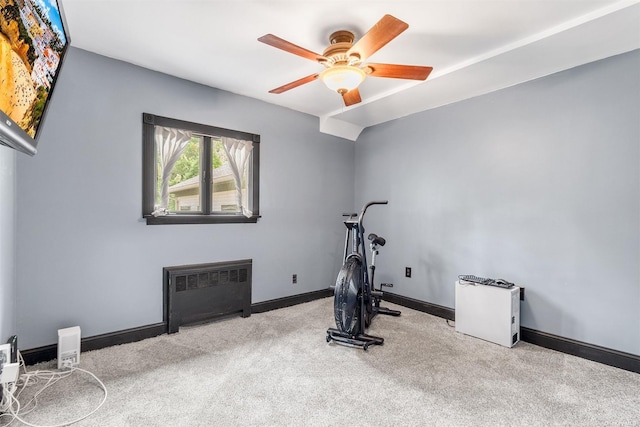 exercise room featuring carpet floors, radiator heating unit, a ceiling fan, and baseboards