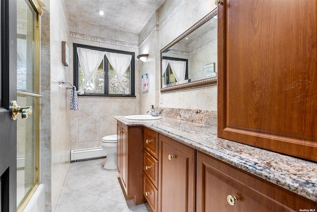 bathroom featuring toilet, an enclosed shower, a baseboard heating unit, vanity, and tile patterned flooring