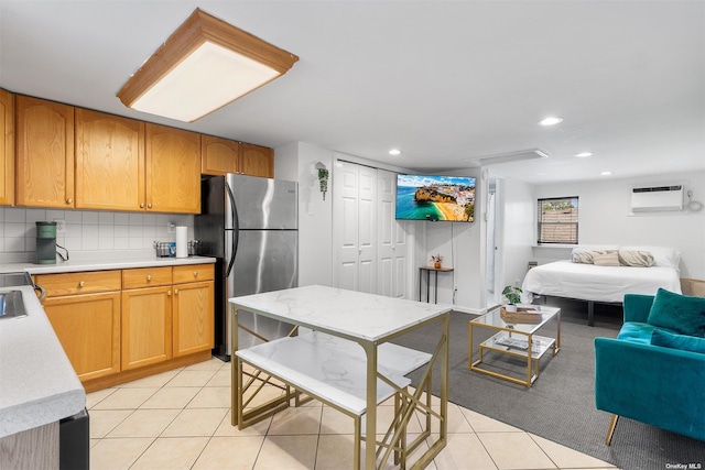 kitchen featuring light tile patterned floors, light countertops, backsplash, and freestanding refrigerator