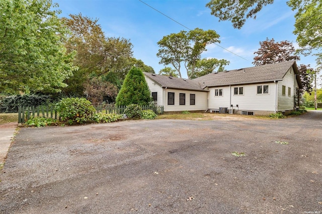 view of front of house featuring central AC unit and fence