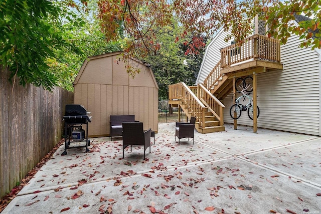 view of patio / terrace with a fenced backyard, stairway, a grill, an outdoor structure, and a shed