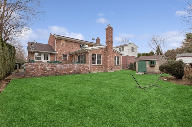 back of property featuring a chimney, a storage unit, a yard, an outdoor structure, and brick siding