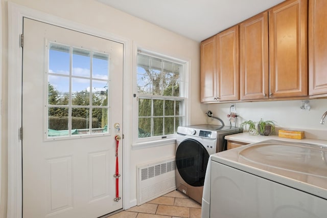 washroom with washing machine and dryer, radiator, and cabinet space