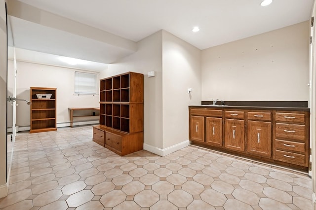 interior space featuring a baseboard radiator, recessed lighting, a sink, baseboards, and baseboard heating