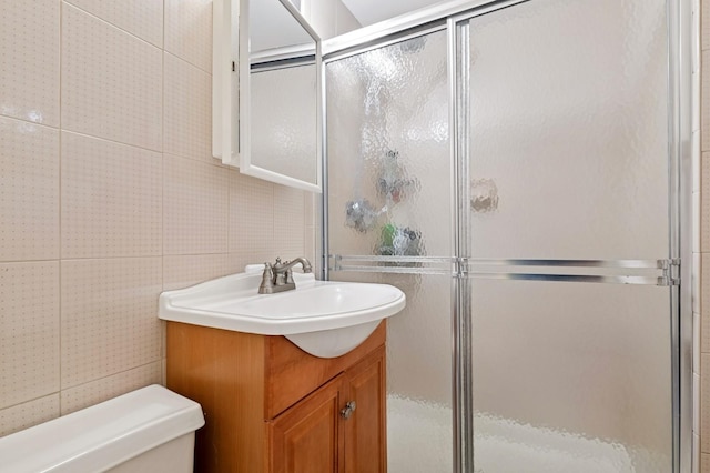 bathroom featuring toilet, a shower stall, and vanity