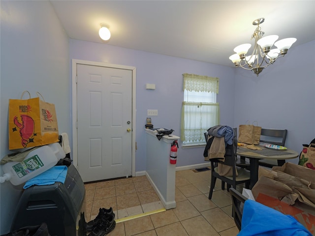 foyer entrance with baseboards, light tile patterned flooring, visible vents, and an inviting chandelier