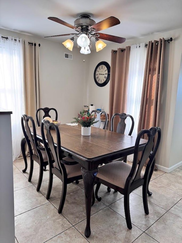 dining space with ceiling fan, visible vents, and light tile patterned flooring