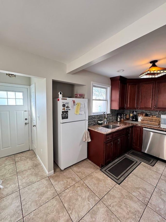 kitchen with dishwasher, tasteful backsplash, a sink, and freestanding refrigerator